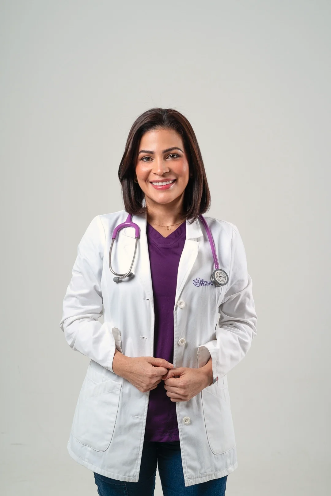 La doctora sonriente con las manos juntas