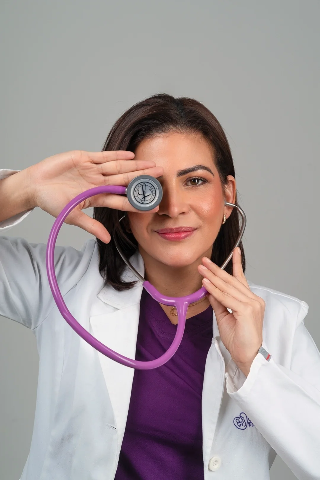 La doctora juega con el estetoscopio frente a su ojo