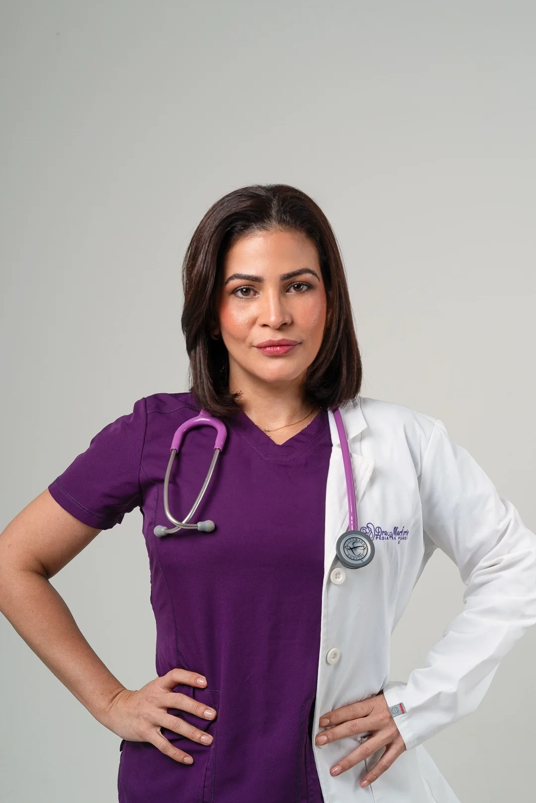 La doctora con uniforme morado y bata